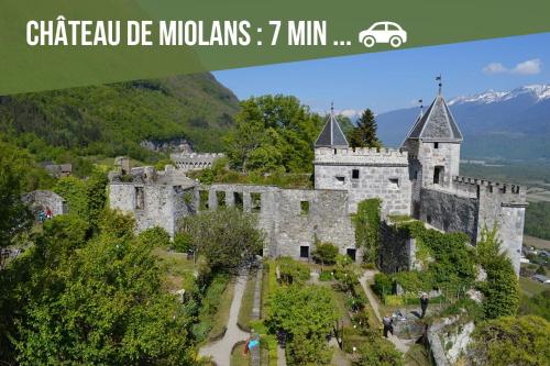 a castle in the mountains with a car parked in front at La Pépinière -Parking Barbecue- 6P in Saint-Pierre-dʼAlbigny