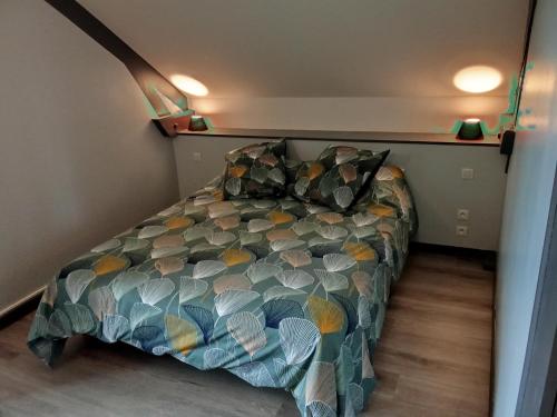 a bedroom with a bed with a colorful comforter at la passerelle in Maurs
