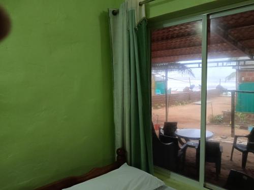 a bedroom with a window with a view of a yard at Bhadrakali Beach Front Stay in Gokarn