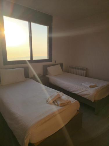 two beds in a room with two windows at Orion, Hills of Zaarour in Zaarour