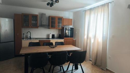 a kitchen with a wooden table and black chairs at House Solis in Banjol