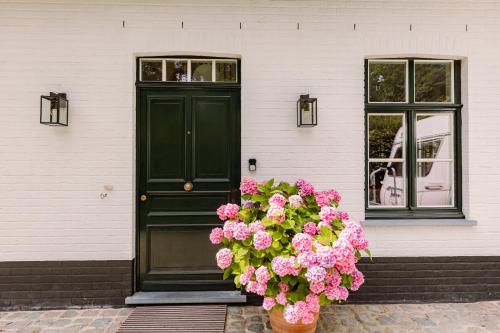 eine grüne Tür mit rosa Blumen vor einem Haus in der Unterkunft Huswell - Two guest-rooms in stylish villa - free bikes in Brügge
