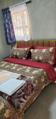 a bedroom with two beds with blankets and pillows at Binu Motel in Kempton Park