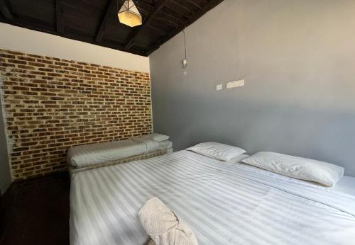 a bedroom with a bed and a brick wall at Le Lodge Villa in Kuantan