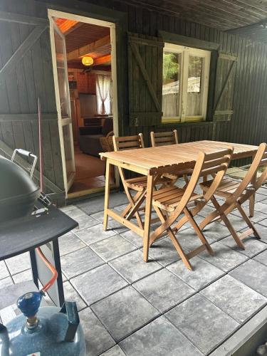 a wooden table and chairs on a patio at Domek Pawła in Smerek