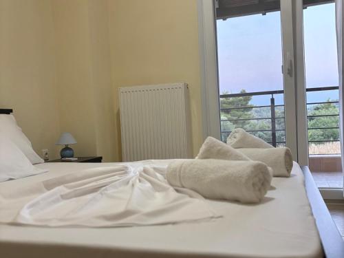 a white bed with towels on it with a window at Villa Beauty in Paliouri