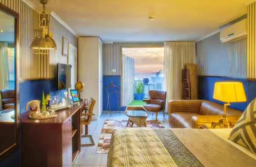 a hotel room with a bed and a living room at TLV Beach 88 Hotel And Spa in Tel Aviv