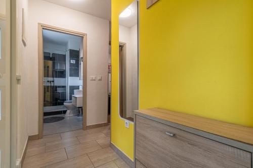a bathroom with a yellow wall and a mirror at House Nina in Pazin