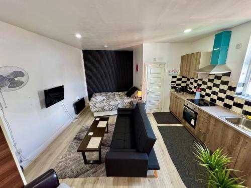 a small living room with a couch and a kitchen at Self-Contained Studio with kitchen & bathroom - Warm Welcome Inn , Stirchley in Birmingham