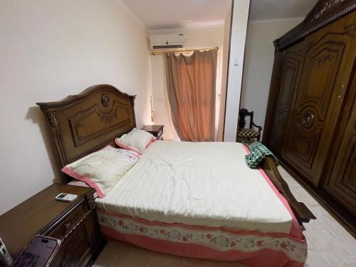 a small bedroom with a bed and a dresser at Elhlal luxury apartment in Hurghada