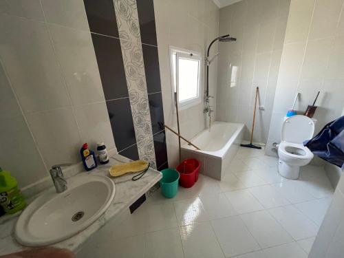 a bathroom with a sink and a toilet and a tub at Elhlal luxury apartment in Hurghada