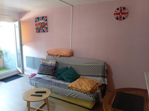 Cette petite chambre comprend un lit avec des oreillers. dans l'établissement studio meublé ensoleillé fibre Bouygues, à Nîmes