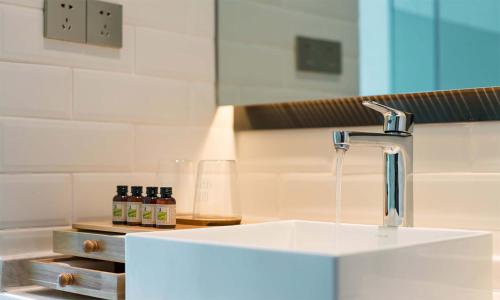a sink with a faucet in a bathroom at Chen Jia Garden Hotel in Xingping