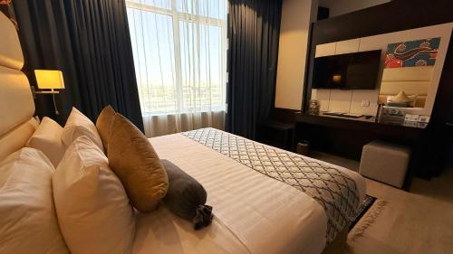 a bedroom with a bed with pillows and a television at Holiday Villa Hail in Hail