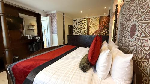 a bedroom with a large bed with white and red pillows at Holiday Villa Hail in Hail