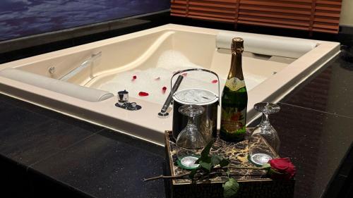 a bath tub with a bottle of wine and two glasses at Holiday Villa Hail in Hail