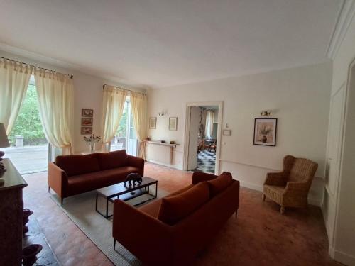 a living room with two couches and a table at Le Domaine des Buis in Albon