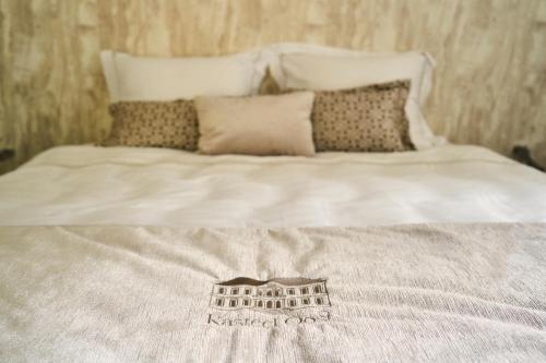 a bed with a white blanket with a building on it at Hotel Kasteel Oost in Valkenburg