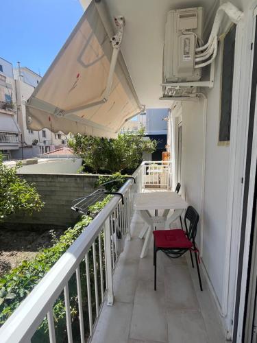 a balcony with a table and a bench on it at Cozy Apartment in central Kiato in Kiáton