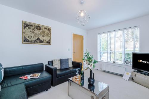 a living room with a black couch and a tv at Stunning Riverside 3-Bed Home by 53 Degrees Property in Manchester with Garden & FREE Parking! in Manchester