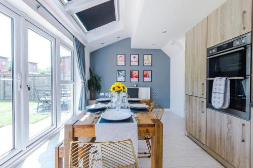 a dining room with a table with flowers on it at Stunning Riverside 3-Bed Home by 53 Degrees Property in Manchester with Garden & FREE Parking! in Manchester