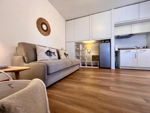 a living room with a couch and a kitchen at Casa della Conchiglia Castiglioncello in Castiglioncello
