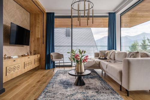 a living room with a couch and a large window at Landscape Villas - LoftAffair Spa Collection in Kościelisko