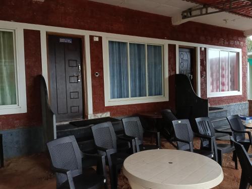 a room with chairs and a table and windows at Bhadrakali Beach Front Stay in Gokarn