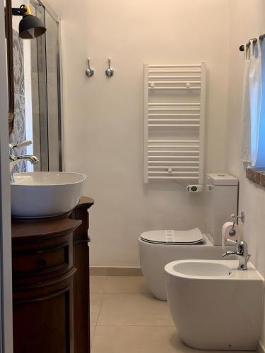 a bathroom with a sink and a toilet and a mirror at Cà Bianca in Casorzo