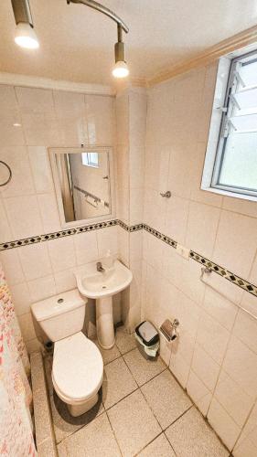 a bathroom with a toilet and a sink at Kunturi in Arica