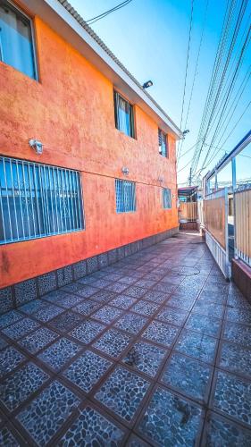 an empty street next to a orange building at Kunturi in Arica