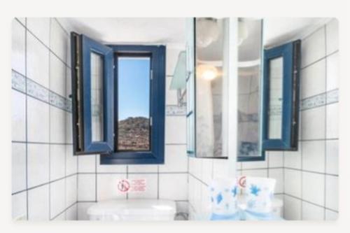 a bathroom with three windows and a sink and a sink at eleni's cozy appartment in Kástron