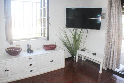 a room with two bowls on a dresser and a tv at Habitaciones Doña Cris in Puerto del Carmen