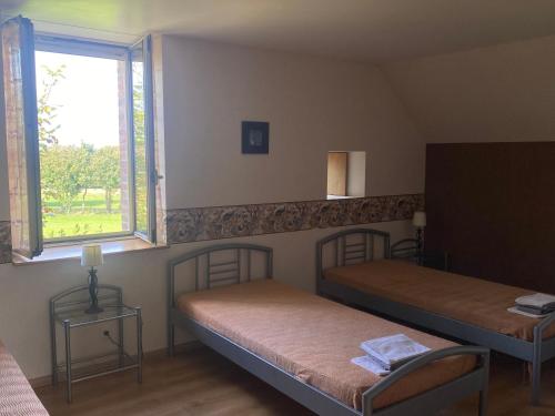 a room with two beds and a window at Les Preaux in Carelles