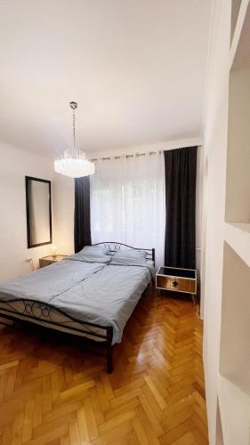 a bedroom with a bed and a chandelier at Banja Luka Apartment Brigita in Banja Luka