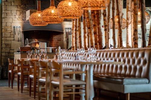 a dining room with tables and chairs and chandeliers at North Lakes Hotel and Spa in Penrith