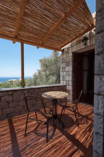 a patio with a table and chairs on a deck at CASA DI MANI KOTRONI Vacation 2 bedroom Maisonette with shared pool in Kotrónion