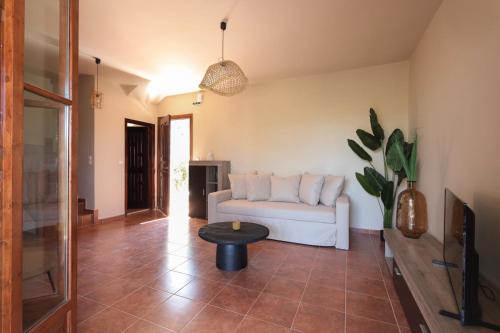 a living room with a white couch and a table at CASA DI MANI KOTRONI Vacation 2 bedroom Maisonette with shared pool in Kotrónion