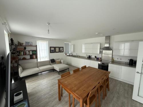 a kitchen and living room with a table and a couch at Modern 2 Bed Apartment in North Oxford in Oxford