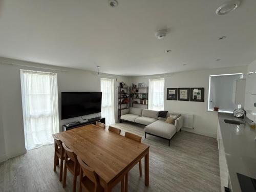 a living room with a table and a couch at Modern 2 Bed Apartment in North Oxford in Oxford