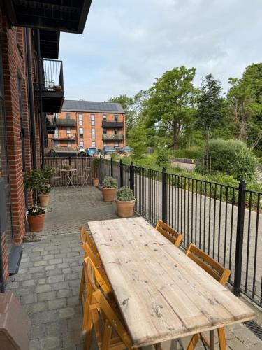 a wooden table and chairs on a patio at Modern 2 Bed Apartment in North Oxford in Oxford