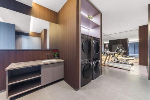 a laundry room with three washer and dryer at 沈阳月星环球港万信瑞铂酒店 in Shenyang