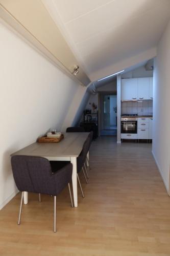 Un comedor con mesa y sillas y una cocina. en Viva la Vida, en Bergen