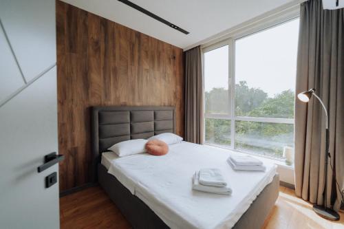 a bedroom with a bed and a large window at Quiet 1BR Retreat 2min to Transit and Shops in Chişinău