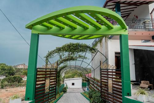 a green archway leading to a building with a pathway at Hotel Eastern Villa in Trincomalee