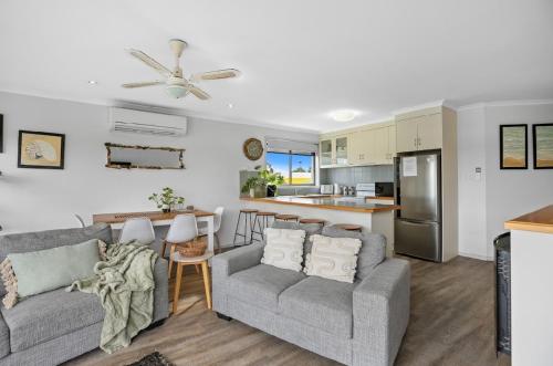 a living room with two couches and a kitchen at Driftwood Townhouse - Waterfront-Central Location in Lakes Entrance