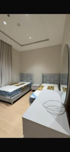 a room with two beds and a mirror at كمباوند ماربيلا الكورنيش شقة in Ar Rākah