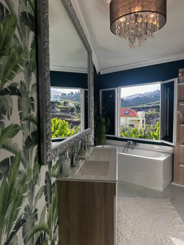 a bathroom with two sinks and a large mirror at Miguels Seaview Corner in Ponta do Sol