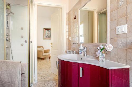 a bathroom with a red sink and a mirror at 2 Suite a due passi dal Mare, Wi-Fi e Natura in Pescara