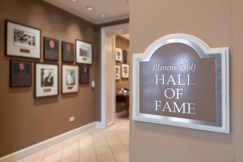 a sign on a wall in a hallway with pictures at The Glen Club in Glenview